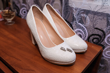 Wedding accessories for the bride. White shoes, earrings