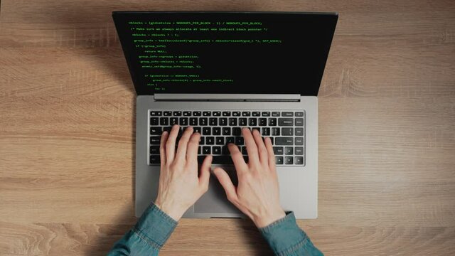 Closeup a man hands are typing commands of a laptop keyboard. A man is writing a program. The developer is coding. Code on the laptop screen. Concept of programming and development web.