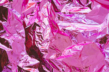 Holographic foil background texture in pink and purple bright colors.