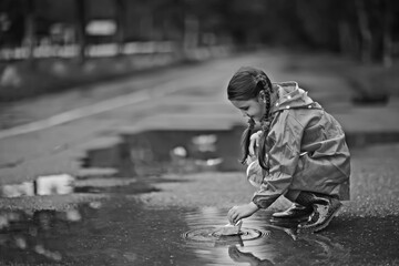 paper boat in a puddle of rain / autumn weather concept childhood