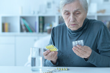 Sick senior woman taking medicine