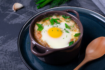 Garlic bread soup with egg baked in the oven in a portion saucepan - 428805194