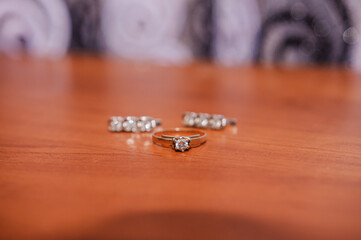Earrings, gold ring with a gem on a brown background