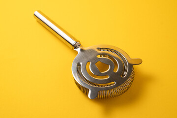 Sieve for cocktails. Cocktail strainer on yellow background. Bartender strainer. Bartender tools