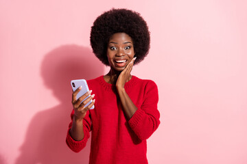 Portrait of astonished positive dark skin lady hand on cheek new follow comment isolated on pink color background