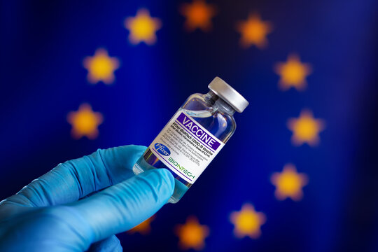 Madrid, Spain - April 16, 2021. Doctor With Vial With Doses Of The Vaccine Pfizer BioNTech For Covid-19 In Front Of The European Economic Community Flag