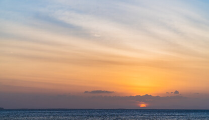 Sunset sky over sea in the evening with colorful orange sunlight, Dusk sky background.