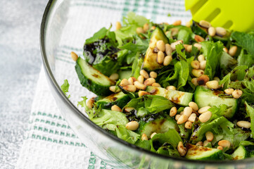 Healthy food concept: green salad with cucumbers, mint, pine nuts and balsamic. Selective focus....
