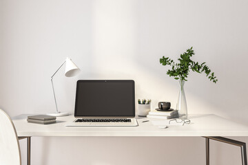 Black laptop screen with copyspace on white table of home office workspace with plant in transparent vase. 3D rendering, mockup