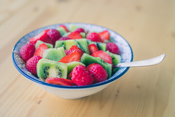 Breakfast fruit bowl with strawberries and kiwis, close up. Healthy lifestyle for vegetarians.