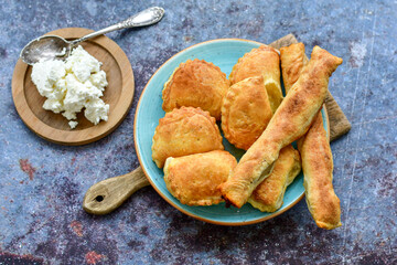 Fresh baked home made  Mini cheese puff pastries and cream  spread cheese.Cheese pie with phyllo pastry and herbs