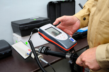 Radiation detector testing. Dosimetrist hands adjusting a portable gamma radiation dosimeter set on...