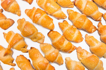Fresh homemade baked goods. Croissants on a white isolated background. Buns on the counter at the bakery