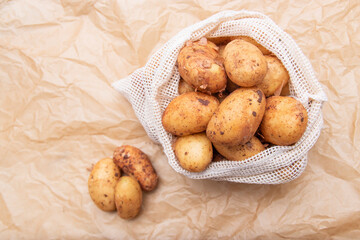 Raw fresh organic potatoes. Full bag of potatoes. Burlap sack with potatoes. Space for text