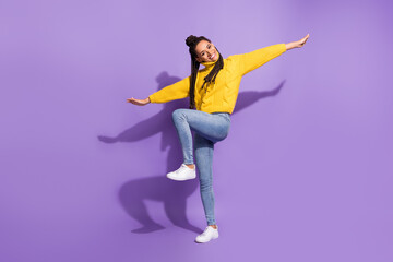 Fototapeta na wymiar Photo portrait of funny girl standing on one pretending to be plane isolated on vivid purple colored background