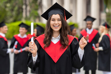 Emotional young woman student having graduation party, cheerfully screaming