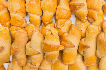 Fresh homemade baked goods. Croissants in heap background. Buns on the counter at the bakery, close...