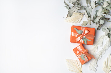Beautiful flat-lay orange gift arrangement decorated by dried flowers including; Cream Ruscus...