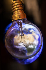 Global warming concept. Earth in the light bulb isolated on black background.