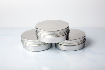 Three metal jars of cream on white background. Aluminum pot for natural cosmetic product. Skin care