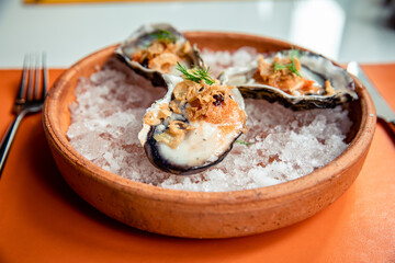 Fresh oysters in shell topping with fried shallot, chili paste, dill and Thai style seafood sauce served on ice