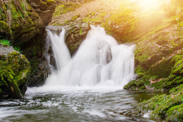 Waterfall on the river in the rocks during sunny day. Tourism concept.