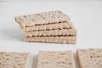 Stacked rye crisp bread on a white wooden background. Copy, empty space for text