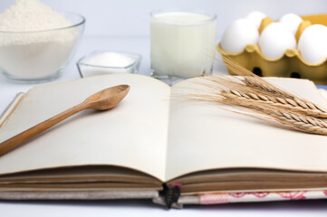 Fototapeta na wymiar Blank vintage recipe book and baking products: flour, eggs, milk and sugar. Baking process. Close-up.