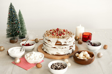 Preparing food for Christmas dinner. Homemade Christmas cake with white icing sugar, nuts and red cranberries