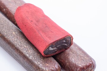 Jerky on a white background. Close-up of basturma sliced into pieces. Several varieties of sausages.