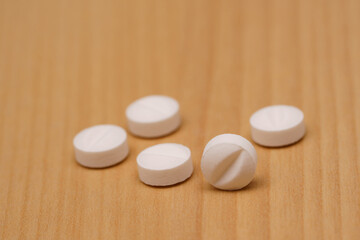 White pills on the table. Selective focus.