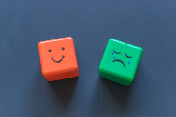 Positive and negative emotions concept, funny faces drawn on cubes.