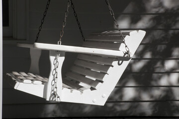Wooden porch swing in the sunshine