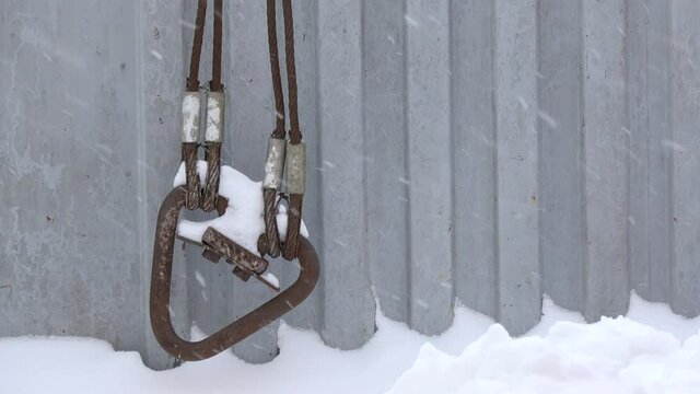 Metal cable on a gray background. Season change of weather. Winter and snow.