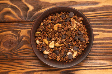 Chocolate granola cereal with nuts in a bowl.