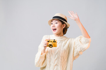 Portrait of beautiful Asian woman tourist holding camera and raised her hand look like to call out someone at the copy space on the left, concept travel insurance, Travel comeback after covid-19.