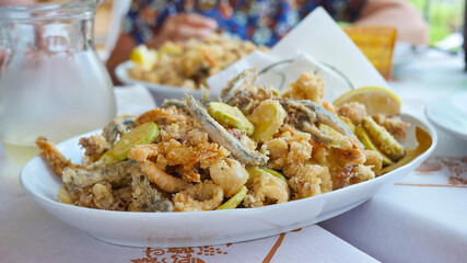 A delicious Italian dish fried seafood: shrimp, squid, octopus and a slices of zucchini. Italian fast food. High quality photo