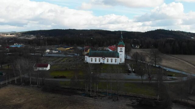 Drone Flying Towards Bjorketorp Church Surrounded By Bare Trees In Ravlanda Town, Harryda, Sweden. aerial
