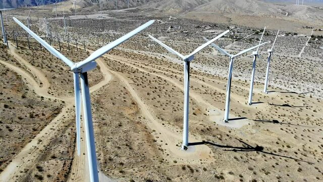 Windmills, wind turbines- aerial 4k drone right to left sweep, energy, green, renewable, huge power generating farm on desert hills,  in Palm Springs, Coachella Valley, Cabazon, California