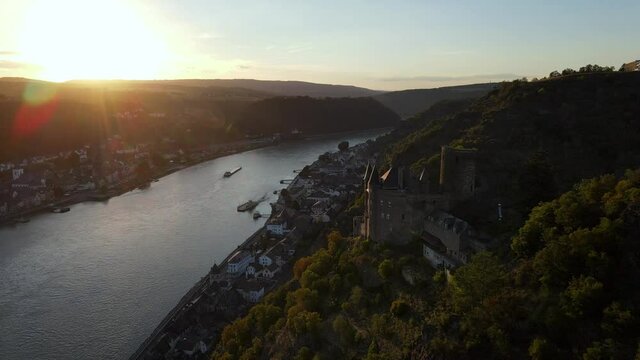 Aerial drone shot flying over the Rhine River and Katz Castle in Germany.