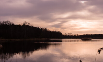 Złote kolory nad stawem wieczorową porą, chmury, odbicie w wodzie © Magdalena