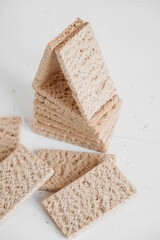 Stacked rye crisp bread on a white wooden background. Copy, empty space for text