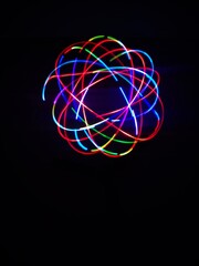 Closeup of Neon Multicolored Spirograph geometric abstract pattern isolated on a Black background with copy space. Made using Long exposure technique.Geometry. Pendulum pattern. © sanju's view