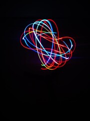 Closeup of Neon Multicolored Spirograph geometric abstract pattern isolated on a Black background with copy space. Made using Long exposure technique.Geometry. Pendulum pattern. © sanju's view