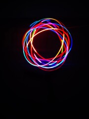 Closeup of Neon Multicolored Spirograph geometric abstract pattern isolated on a Black background with copy space. Made using Long exposure technique.Geometry. Pendulum pattern. © sanju's view