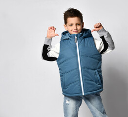 hey look at me. Cheerful guy teenager in a warm blue puffed tank top and jeans, smiling cheerfully...