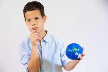School pensive boy holding a world globe isolated over white background