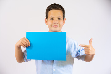 Cute boy pointing finger a blue blank paper isolated over white background