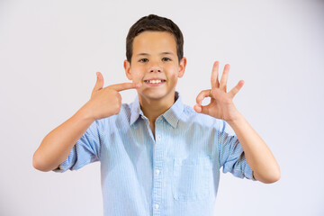 Cute little boy pointing mouth with finger isolated over white background