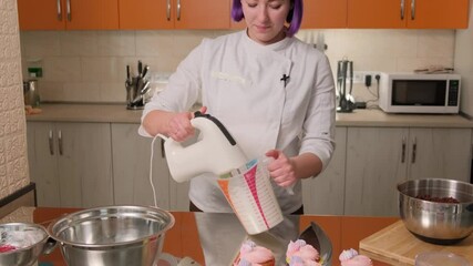 During a master class, a professional chef will tell you how to properly prepare desserts. There are prepared cupcakes with cream on the table.